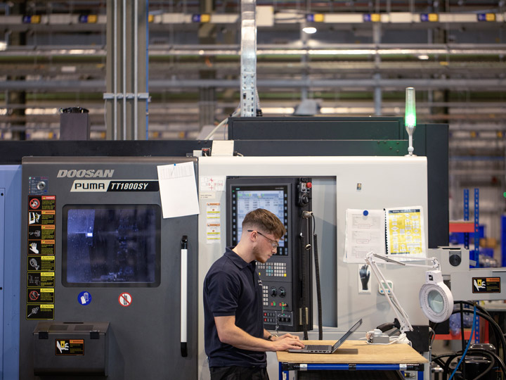 Male employee working on a laptop in a factory